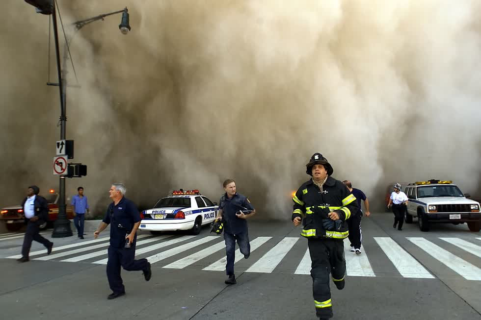 Cảnh sát và lính cứu hỏa chạy trốn khỏi đám mây bụi khổng lồ sau khi tòa tháp Bắc của Trung tâm Thương mại Thế giới sụp đổ. Ảnh: Jose Jimenez/Primera Hora/Getty Images