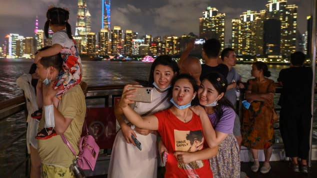 Du khách tạo dáng chụp ảnh ngày 1/9 tại Thượng Hải. Khi người Trung Quốc ở nhà, du lịch nội địa đang phát triển mạnh. Ảnh: Getty Images.