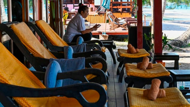 Nhân viên mát xa ngồi chơi vì không có khách trên đảo Koh Tao, Thái Lan. Ảnh: AFP.
