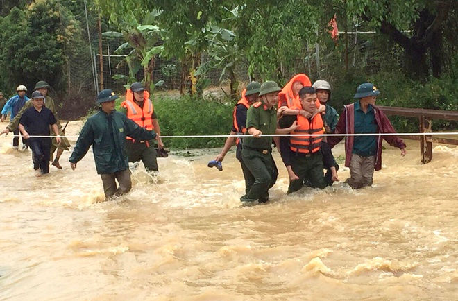 Lực lượng chức năng hỗ trợ người dân di dời khỏi khu vực ngập lụt. Ảnh: Zing