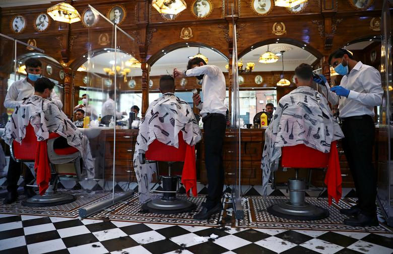 Một tiệm cắt tóc nam tại Savvas Barbers ở London, Anh. Ảnh: Reuters.