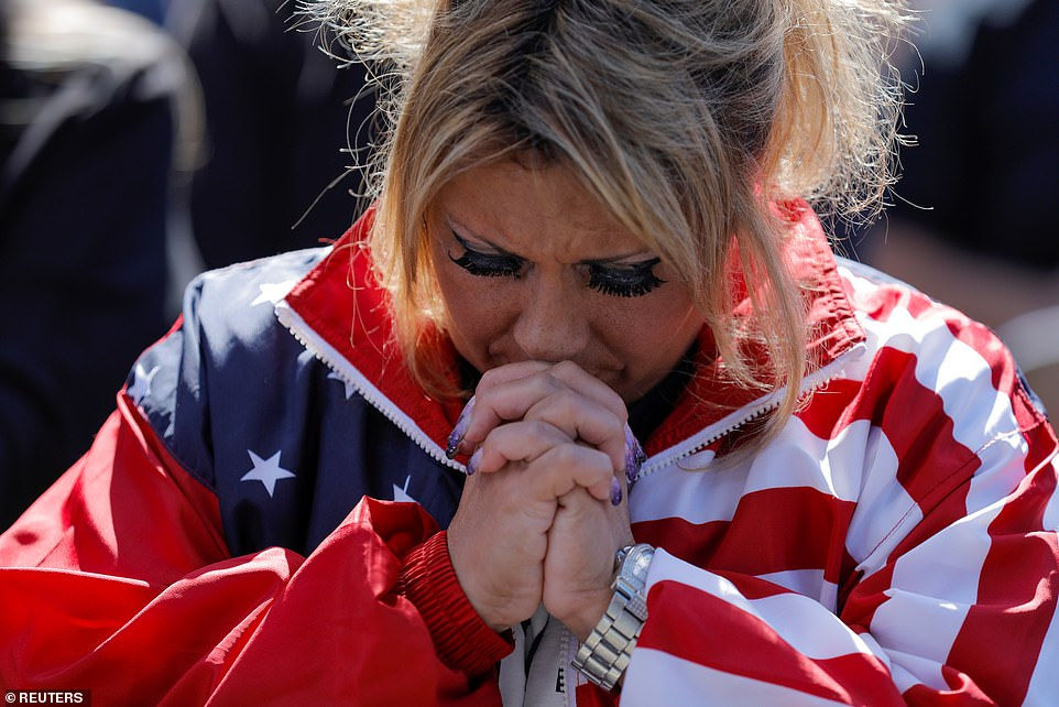   Daniela Taomorina ở Đảo Staten cầu nguyện cho ông Trump trong cuộc tuần hành ở Staten Island, New York ngày 3/10. Ảnh: Reuters.  