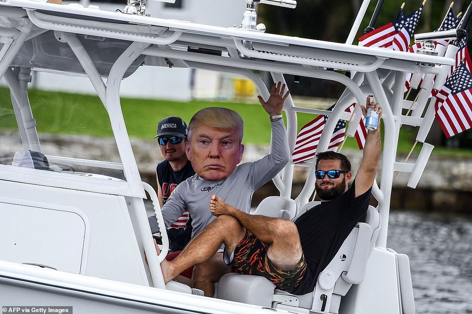   Người ủng hộ đeo mặt nạ ông Trump trong cuộc diễu hành bằng thuyền tại Florida - Ảnh: AFP  