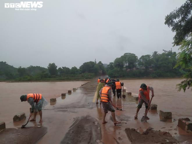Lực lượng chức năng huyện Đakrông (Quảng Trị) dọn dẹp bùn cát bám đầy trên cầu. Ảnh: VTC news