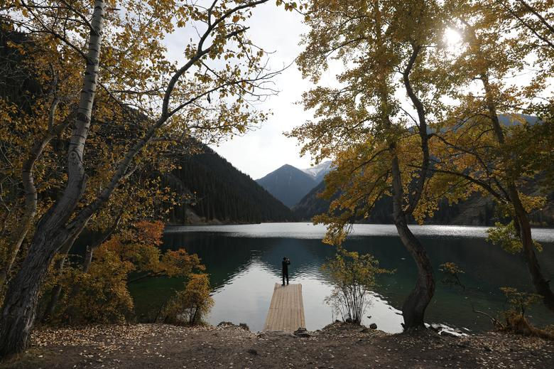Một người đàn ông chụp ảnh trong một ngày mùa thu tại hồ Kolsai ở vùng Almaty, Kazakhstan ngày 30/9.