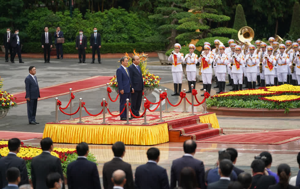 Thủ tướng Nguyễn Xuân Phúc và Thủ tướng Nhật Bản Suga Yoshihide trên bục danh dự, nghe quân nhạc cử Quốc thiều hai nước.  Ảnh: VGP.