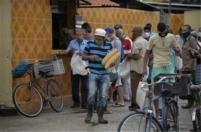   Người dân đeo khẩu trang phòng dịch COVID-19 khi xếp hàng mua bánh mì tại một cửa hàng ở Mayabeque, Cuba ngày 18/6/2020. Ảnh: TTXVN  