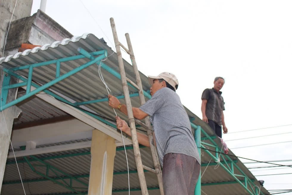   Người dân huyện Bình Sơn (Quảng Ngãi) tất bật chằng chống nhà cửa trước khi bão số 9 đổ bộ. Ảnh: TT  