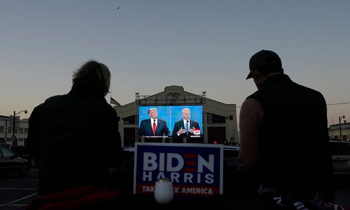 Hai người ngồi xem buổi tranh luận giữa Tổng thống Donald Trump và ứng viên Joe Biden tại thành phố San Francisco, bang California hôm 22/10. Ảnh: AP.