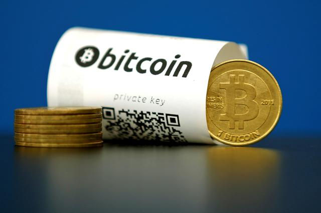  Một tờ giấy Bitcoin (tiền ảo) có mã QR và một đồng xu trong hình ảnh minh họa được chụp tại La Maison du Bitcoin ở Paris, Pháp vào năm 2015. Ảnh: Reuters