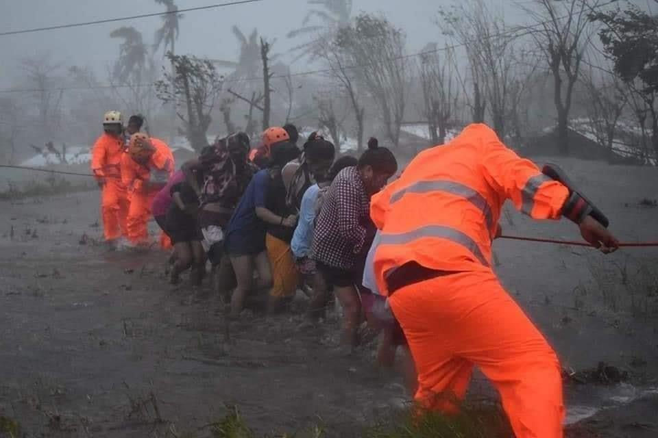 Trong điều kiện mưa ngập và gió mạnh, đội cứu hộ phải cho người dân bám vào sợi dây để di chuyển về phía ôtô đỗ trên đường lớn. Ảnh: Marco Chavez.