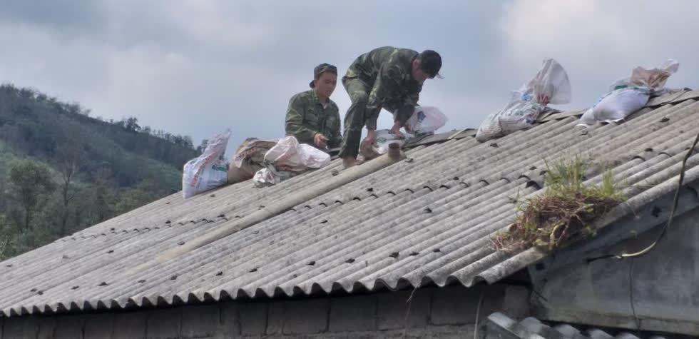 Bộ đội Biên phòng Hướng Lập (Quảng Trị) đang giúp dân chèn chống mái nhà trước khi bão 13 đổ bộ. Ảnh: Gia đình Việt Nam