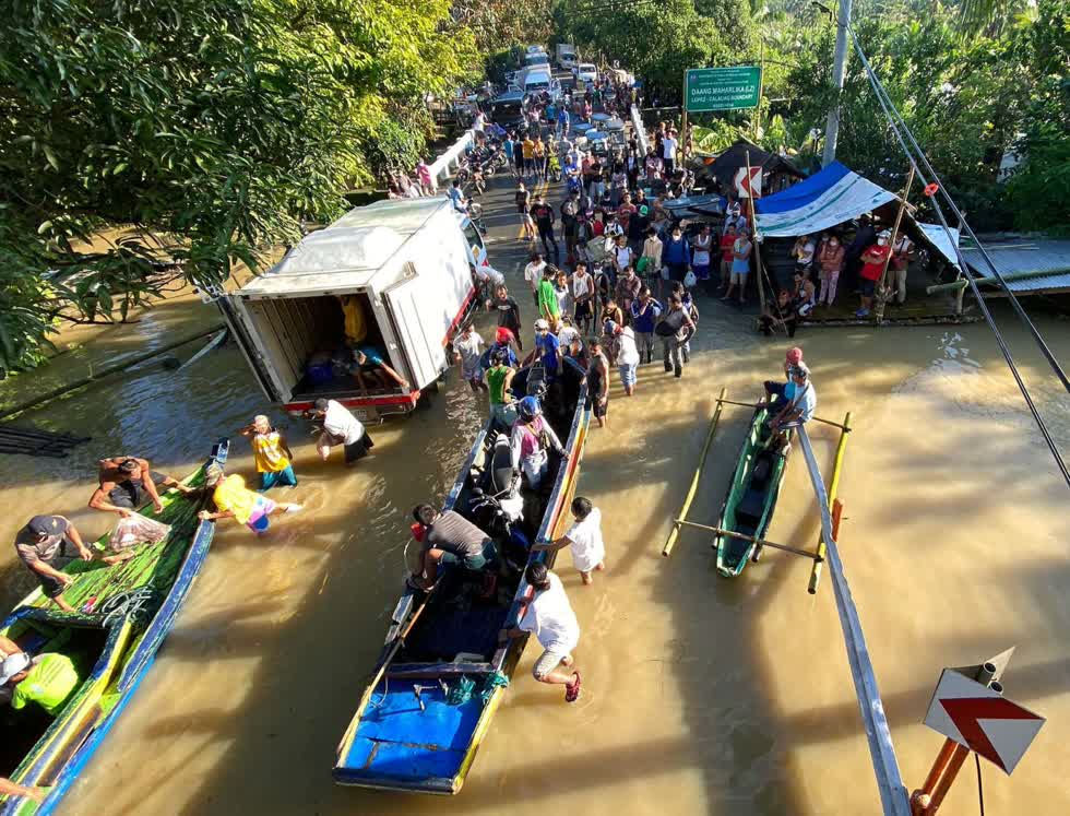 Người dân đi thuyền trên con đường ngập lụt ở thị trấn Lopez. Ảnh: EPA-EFE 