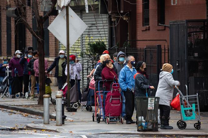 Người dân đeo khẩu trang phòng lây nhiễm COVID-19 khi xếp hàng bên ngoài một cửa hàng thực phẩm ở Brooklyn, New York, Mỹ, ngày 12/11/2020. Ảnh: THX/ TTXVN