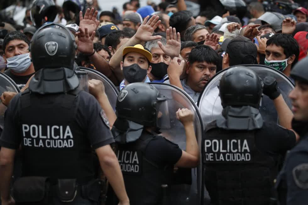 Cảnh sát chặn người hâm mộ bóng đá chờ xem Diego Maradona.