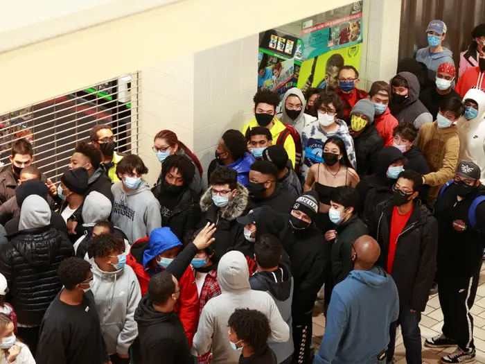 Rất đông người đeo khẩu trang, xếp hàng dài bên ngoài cửa hàng GameStop ở Tysons Corner Center, ở Tysons, Virginia (Mỹ) trước giờ mở cửa. Ảnh: Reuters