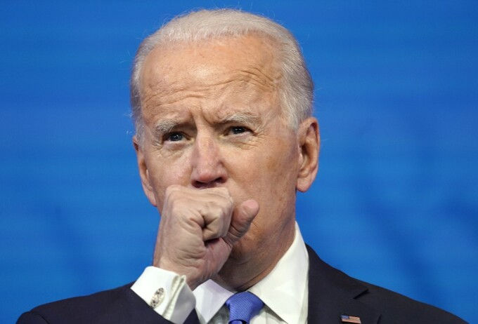 Tổng thống đắc cử Joe Biden che miệng họ khi phát biểu trước toàn nước Mỹ tối 14/12. Ảnh: AFP.