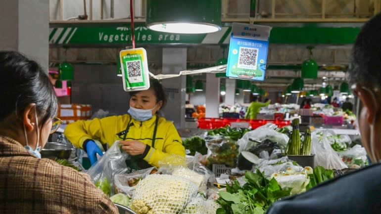 Khách hàng chờ mã thanh toán QR Alipay và WeChat tại một khu chợ ở Bắc Kinh. Alibaba có hơn 700 triệu người dùng hoạt động hàng tháng tính đến tháng 6, trong khi WeChat Pay của Tencent có hơn 800 triệu vào năm 2019. Ảnh: AFP
