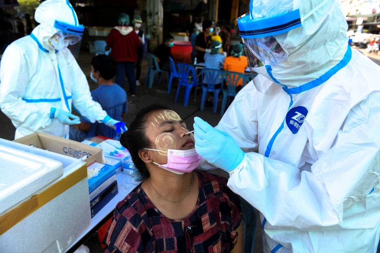  Nhân viên y tế lấy mẫu xét nghiệm cho một công nhân nhập cư tại chợ hải sản trong bối cảnh bùng phát COVID-19, ở tỉnh Samut Sakhon, Thái Lan, ngày 19/12/2020. Ảnh: Reuters.