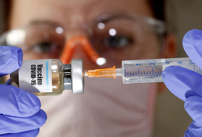 Y tá cầm một lọ được gắn nhãn vaccine COVID-19. Ảnh: Reuters.