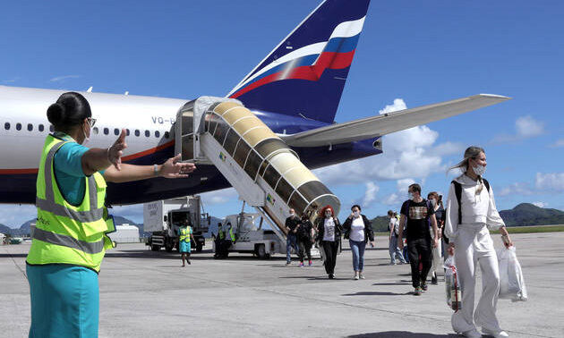 Hành khách rời chuyến bay từ Moskva tới đảo Male ở Seychelles hôm 2/4. Ảnh: AFP.