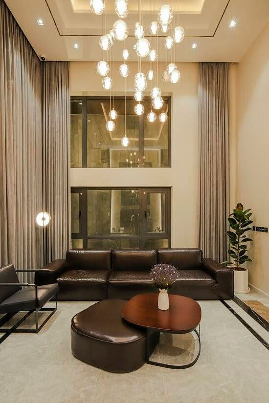 Phòng khách được thiết kế trần cao, tạo cảm giác thoáng đãng. Toàn bộ  nội thất  có tông màu nâu vừa sang trọng, vừa ấm cúng.