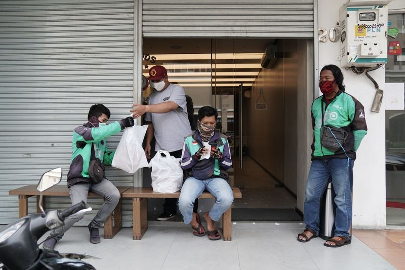 Các tài xế Gojek đợi đơn hàng bên ngoài một nhà hàng ở Jakarta vào tháng 5/2020. Ảnh:Bloomberg