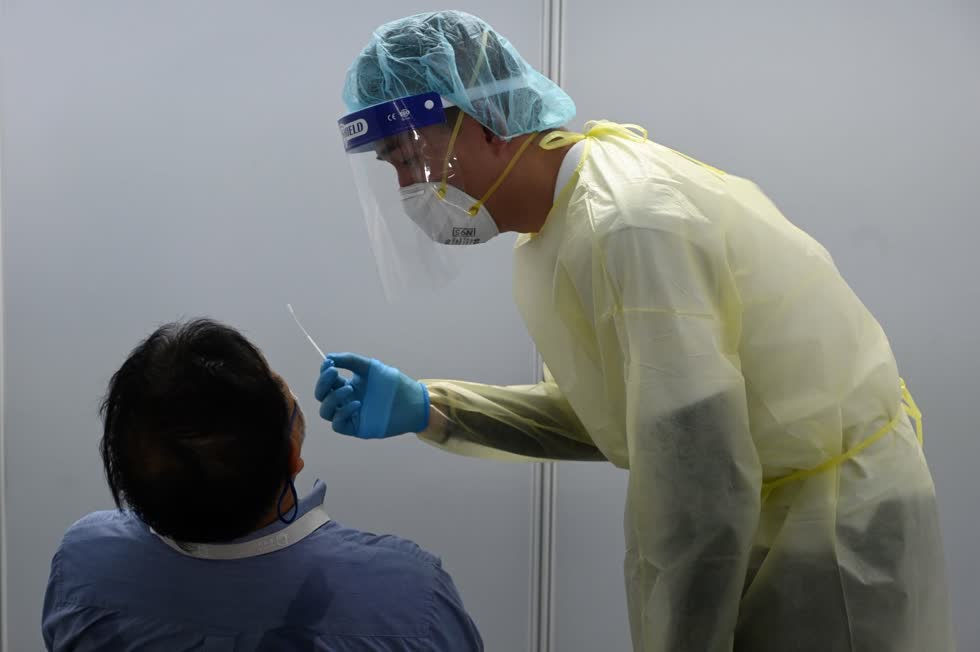 Nhân viên y tế lấy mẫu xét nghiệm COVID-19 cho người dân tại Singapore. Ảnh AFP/TTXVN