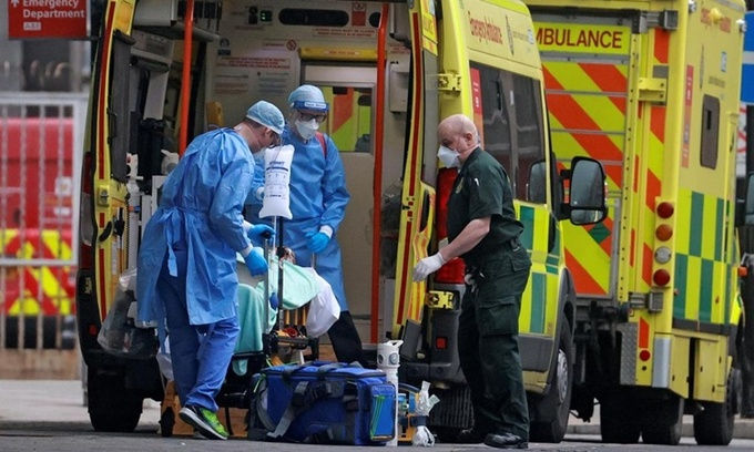Nhân viên y tế di chuyển một bệnh nhân nghi nhiễm COVID-19 tại London, Anh. Ảnh: Reuters.