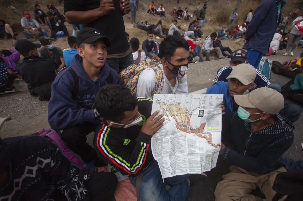   Một người di cư Honduras đang cho mọi người xem hành trình của mình. Ảnh: Sandra Sebastian/AP  