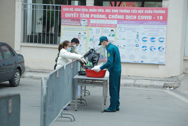 Trường Tiểu học Xuân Phương ngày đầu trở thành nơi cách ly tập trung, phụ huynh hối hả tiếp tế nhu yếu phẩm cho con - Ảnh 5.