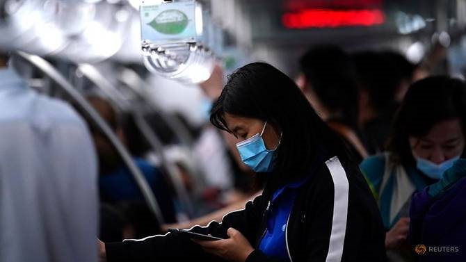 passenger-wearing-a-face-mask-uses-her-phone-on-a-subway-train-in-beijing-2.jpg