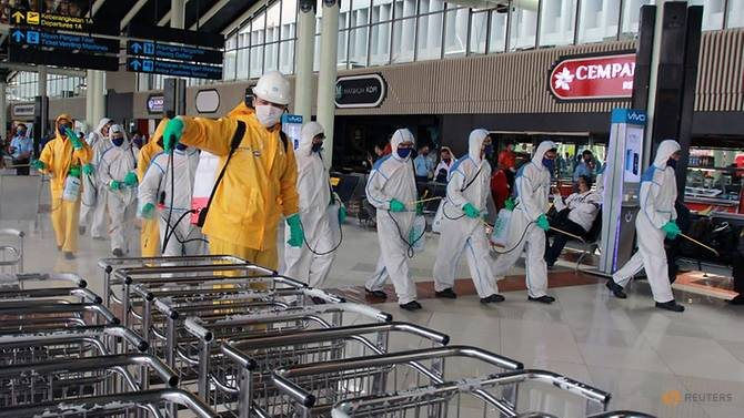 airport-officer-sprays-disinfectant-at-a-soekarno-hatta-international-airport-to-prevent-the-spread-of-coronavirus-disease-covid-19-in-tangerang-2.jpg