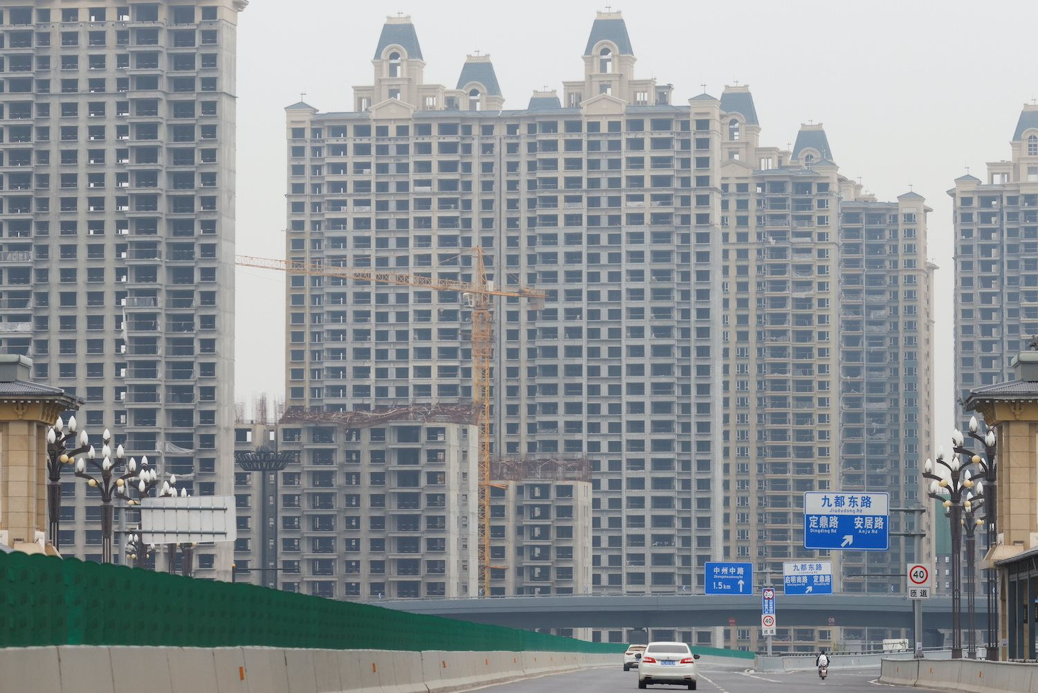 vehicles-drive-near-unfinished-residential-blocks-built-by-evergrande-oasis-a-housing-complex-developed-by-evergrande-group-in-luoyang-china-on-sept-16-2021.-rtrscarlos-garcia-rawlins.jpg