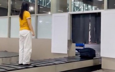 Mời nữ hành khách đứng trên băng chuyền hành lý sân bay lên làm việc