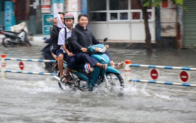 Học sinh ở Sài Gòn bì bõm lội nước sau giờ tan học do mưa lớn kéo dài từ sáng đến trưa