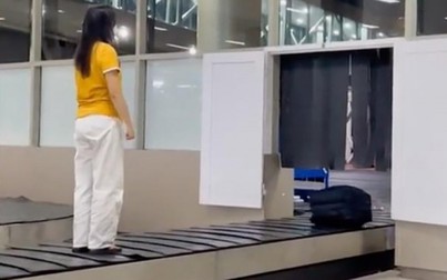 Mời nữ hành khách đứng trên băng chuyền hành lý sân bay lên làm việc